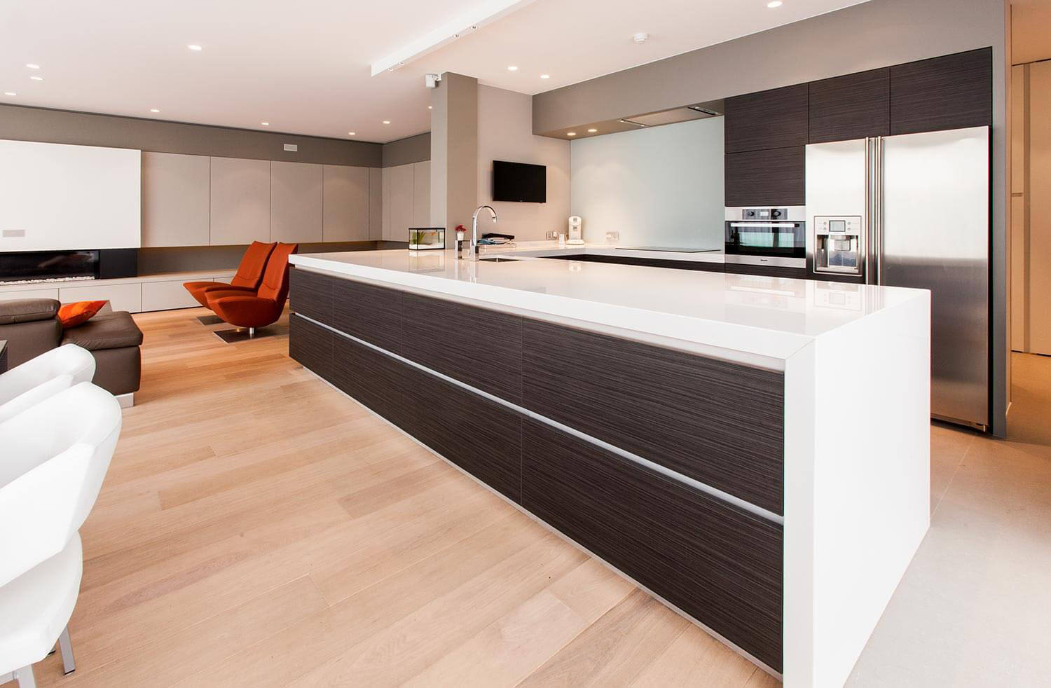 foto van een moderne open living, keuken en eetkamer, detail van de keukenkast gezien vanuit de living