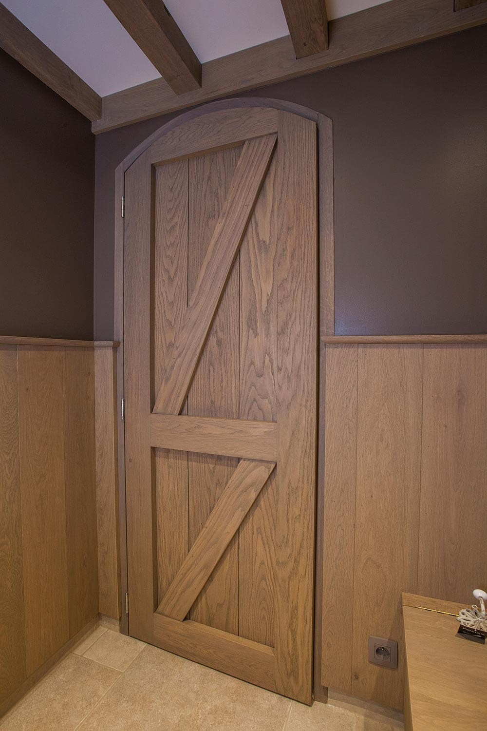 toegangsdeur tot Wellness in een country/cottage stijl. materiaal van de deur is hout, ook de lambrisering is in hout