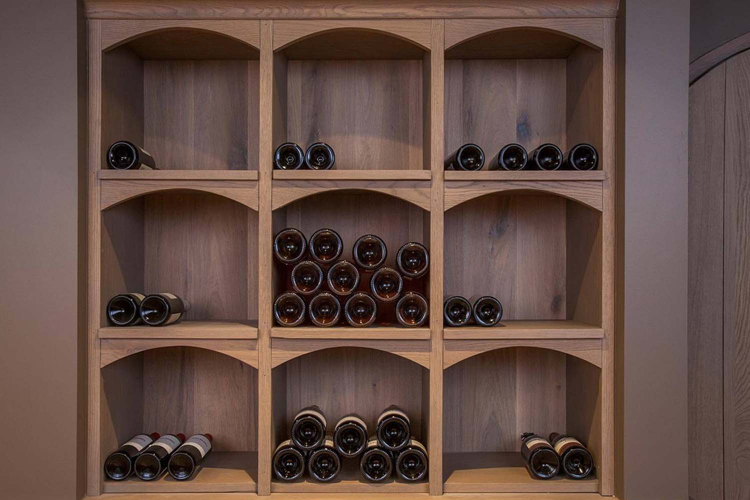 detail foto van flessen op schabben in wijnkelder