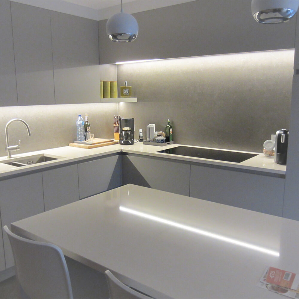 foto van de keuken in de aanbouw. De algemene kleur van de keuken is neutraal grijs met een wit werkblad in composiet.